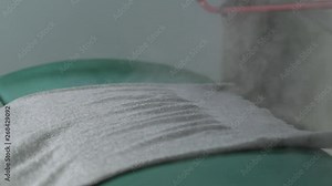 Women's jumper lying on special machine during steaming in dry-cleaning salon, close-up on steam rising in air. Industrial equipment steaming clothes needed delicate care after dry cleaning