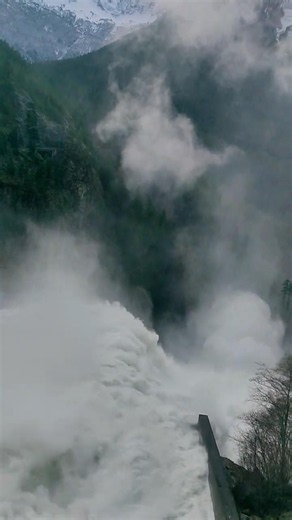 Dramatic view of water spilling over dam