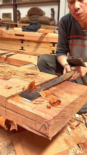 Expert Woodworker Using Traditional Chisel and Adze Tools