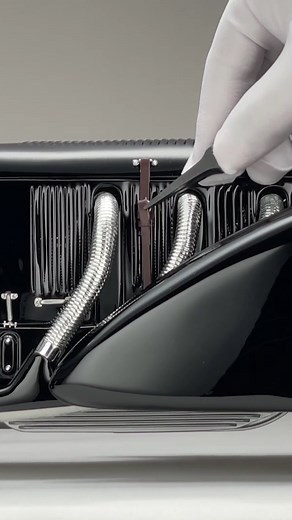 Discover the details of the Ralph Lauren Mercedes-Benz SSK "Count Trossi" at 1:8 scale. Draped in an exquisite black exterior paint scheme, this 1:8 scale model features the iconic swooping fenders and elegant lines that define this true German classic. The engine cover, which can be lifted up on both sides of the model after careful undoing of the intricate leather strap fastenings, reveals the 7.1-litre straight-six engine. This powerful engine was a key factor in the SSK's reputation, contrib