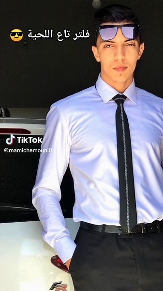 Man in Formal Attire Beside Sports Car