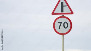 Speed limit on the road. 70 km per hour. Crossroads. Slow down. A sign shows a speed limit of 70. Vehicles safety movement control on the road. blurred in the background