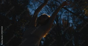 Woman, dancer and night in forest, trees and moving body for fantasy, nature and freedom in performance. Person, girl and artist with dancing, steps and outdoor in dark woods, environment or park