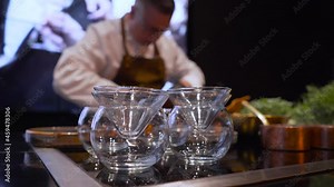 glassware in the restaurant, the chef is working in the background.
