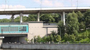 Embankment, walking people and two-level bridge at summer day