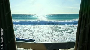 Horizontal video footage, view from a hotel window by the sea ocean, waves crashing onto the shore, marine horizon