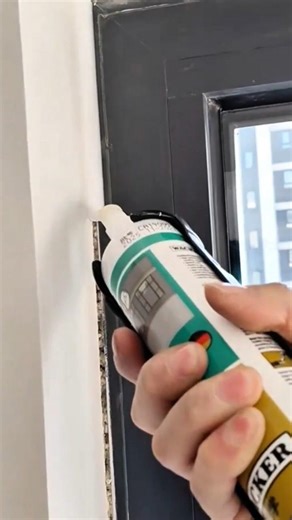 applying white silicone sealant on the gap between window frame and wall using manual glue gun tool