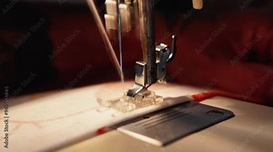 A man's hands sew on a sewing machine. Man puts a straight stitch on a cotton fabric