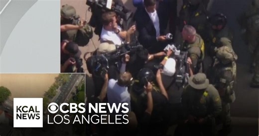 Immigration officials outside Gov. Newsom's LA news conference