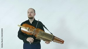 young musician demonstrates the technique of playing nickelharpa, a medieval authentic Swedish Scandinavian musical instrument