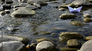 paper boat floating in a stream