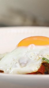 Chorizo Hash - a fiery, flavour-packed dish with crispy smashed potatoes, spicy chorizo, chilli, and sherry vinegar, topped with fried eggs, spring onions, and coriander. Perfect for a bold breakfast or comforting supper. Get the recipe on the Lakeland blog. | Lakeland