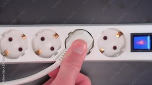 Electrical extension cord with electrical plug. Extension cord on a gray background. The black and white plug are plugged into the socket in the extension cord.