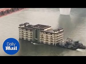 Bizarre moment a building FLOATS downstream in China
