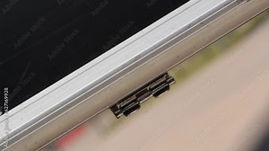 A man grabs the handle of a heavy stainless steel briefcase and puts back down.