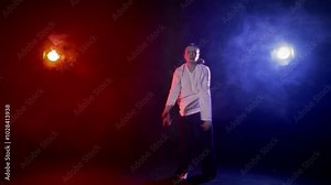 Flexible female dancer performing jumps in studio with smoke and art lighting. Slow motion shot, talented woman dancing contemporary choreography, self-expression, art and creativity, acrobatic trick