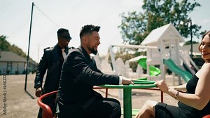 A group of adults play on the playground and laugh like children.Adults play on a children's swing.The concept of nostalgia for childhood