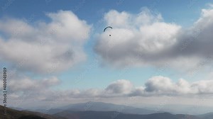 People try paragliding flying with parachutes against clouds