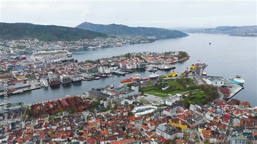 star shaped green fortress stands historic harbor point colorful houses stationary industrial vessels surround deep blue water norway bergen city center port star-shaped architecture
