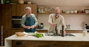 Mature Male Gay Couple having Fun Cooking Together at Home in the Kitchen