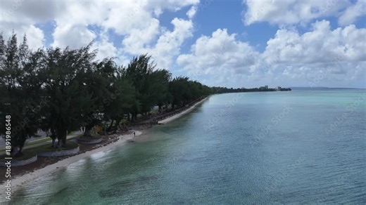 Trace the path of endurance in paradise. This sweeping aerial footage captures the renowned coastal running course along Saipan's west coast, famous for hosting international marathons. Stretching fro