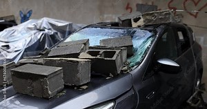 Brick on broken car windshield and broken glass