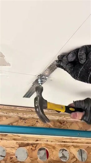 Securing Metal Brackets to Ceiling Boards with Hammer and Precision