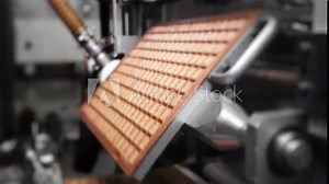 Automated chocolate wafer production line with industrial robot.
