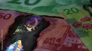 A still shot of Canadian banknote's security feature against counterfeiting, light shifting on the portrait of Canada's longest prime minister. This bank note is part of the polymer series banknotes.