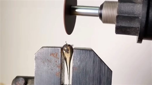 鲁珀特之泪头部坚硬，全靠表层强压应力牢牢锁紧玻璃。砂轮机切破这层防护后，内部被压制的拉应力瞬间失衡，整颗泪滴便轰然崩解。