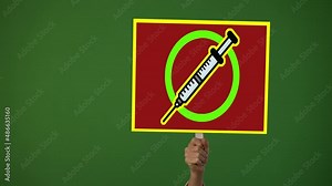 Hand holding sign banner with Syringe and NOT symbol over it, in protest of covid 19 vaccine stop immunization no tax concept on green screen.