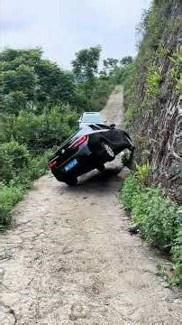 Two Vehicles Met In A Rural Area, And One Car Climbed Over A Wall.