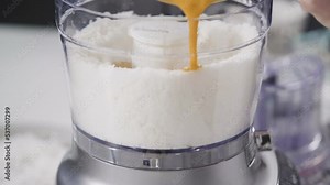 Mixing ingredients in a food processor to prepare homemade coconut cookies.