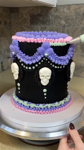 @cakes.by.taylor on Instagram: "Skull cake but make it girly 💀🎀 Loved this one... black cocoa buttercream (no food coloring!) and those pastel details just pop against it. Spooky, sweet and totally one of my faves 🖤#SkullCake #HalloweenCake #CakeDecorating"