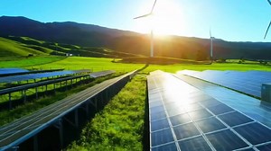 Download Sustainable energy in scenic field with solar panels and wind turbines generating clean power for free