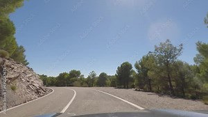 First person view, FPV, from dashcam of car driving mountain road from Calar Alto Observatory to Tabernas Desert in Almeria, Andalusia, Spain, Europe. Road trip in POV, with bright, sunny, clear sky