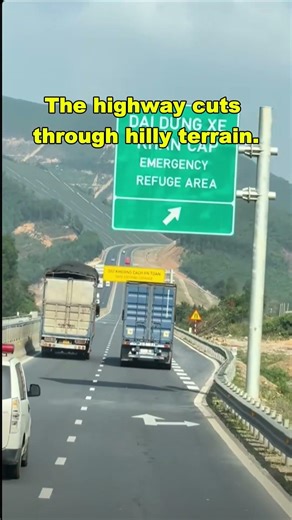 The highway cuts through hilly terrain. #BigTruckPower #HeavyDutyTrucks #HillClimbChallenge