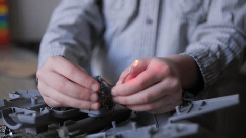 clip-4028065825-child-hands-holding-glowing-red-led-pcb