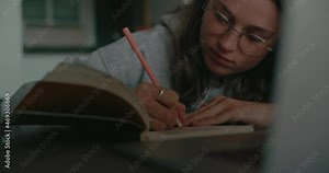 Young female student sit at home and write down notes text