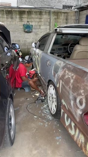 Peeking at the repairman under the car scraping the car paint