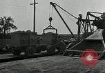 1930 – United States USA: Workers on concrete spreader and use hand tools during a road construction in the United States.
