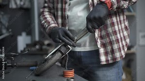 Eco-friendly electric vehicle repair service. Caucasian male electric transport repairman at work at the station. Man workshop worker repairs electric pushing scooter at shop for repair and service.