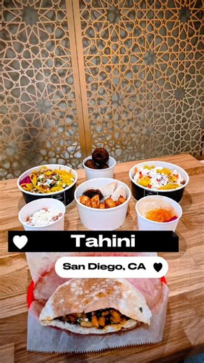 Crystal & Stephen Kamada on Instagram: "I think we just found the G.O.A.T. falafel in San Diego and we won't try to gate keep it 🙌. @eattahini just opened up a new location in Mission Valley so we had to check it out. We've been a fan of their coffee shop Finjan for years, but this was actually our first time trying the food at Tahini and we're kicking ourselves for waiting this long. We shared: 🧀 Fried Halloumi Cheese Stix 🥗 Cumato Salad 🫓 Hummus w/ Pita 🍟 Tahini Fries 🧆 Falafel 🥙 The Es