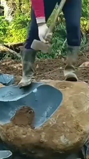 A large stone that is being carved using a large hammer