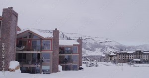 Panning on snowy condos at Colorado ski resort in winter in slow motion