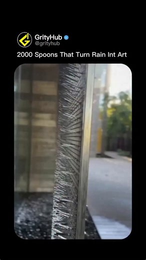 Grity Hub on Instagram: "2000 ordinary spoons transformed by rain into a hypnotic liquid metal waterfall. 🌧️🥄 An engineering marvel uses 2,000 precisely aligned stainless steel spoons mounted on cascading frames that channel rainwater into shimmering rivulets. Each spoon acts as a micro-reservoir, catching droplets from above and releasing them through strategically drilled drainage holes sized to create laminar flow without splashing. The installation spans 15 meters vertically, with spoon or