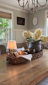 𝐓𝐚𝐦𝐦𝐲 🌿Lavender Brook Home🌿 on Instagram: "Cozy Fall Centerpiece Styling 🍂✨” This fall-inspired centerpiece is all about texture, warmth, and that cozy autumn glow. A long woven tray sets the foundation, layered with a vase of full hydrangeas in soft fall tones, a glowing glass pumpkin, and the flicker of candlelight beneath a warm rechargeable lamp. I tucked in a bowl of dried gourds and some pretty floral-inspired napkins for a gathered, lived-in feel. If you love cozy fall decor that 