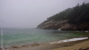 Crashing waves on Sand Beach in Acadia National Park, Maine. Surrounded by cliffs, this small stretch of coast is the largest sandy beach in Acadia. Rough surf on foggy, stormy day.