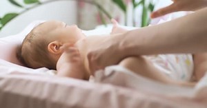 Young Mother Changing Her Baby's Diaper