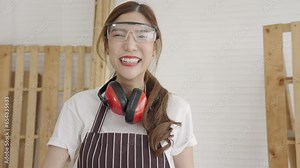 Beautiful Asian female carpenter woodwork stands tall, showing off a cordless drill. Owner business, Small business.